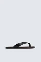 Sandalia tipo chancleta negra con suela plana marrón y dos tiras en el empeine.