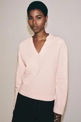 Sudadera de algodón en color rosado, con escote en V y mangas largas de corte holgado.