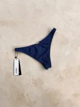 Bombacha de bikini vedetina con estampado geométrico en tonos naranja, celeste y rosa.