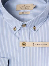 Camisa de manga larga a rayas verticales azules y blancas, con cuello abotonado y logo de la marca bordado en el pecho.