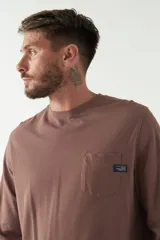 Remera de hombre color marrón, de manga larga con puño, escote redondo y bolsillo en el pecho con etiqueta de la marca.