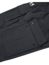 Pantalón cargo Under Armour Woven para hombre, color negro, de corte ajustado con bolsillos laterales y logo de la marca en la pierna izquierda.