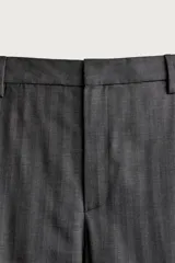 Pantalón de vestir gris con diseño de rayas sutiles, de corte relaxed fit, con pinzas delanteras y trabillas para cinturón.