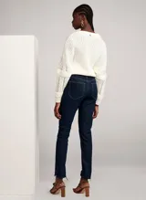 Pantalón de jean azul oscuro de corte recto, con tiro alto, cinco bolsillos y cierre frontal con cremallera y botón.