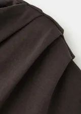 Camiseta asimétrica de manga corta color marrón oscuro, con diseño recto y detalles fruncidos en el escote.