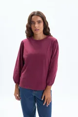 Remera de manga larga color bordó, con cuello redondo y mangas tipo balloon con puños elásticos.