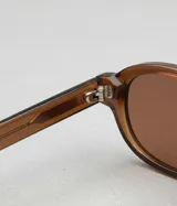 Lentes de sol con montura ovalada de acetato color marrón translúcido (tortoise/carey) y lentes degradados color marrón.