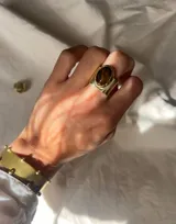 Anillo de bronce con piedra ojo de tigre ovalada.