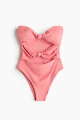 Malla enteriza strapless color rosado con secciones cut-out y detalles de nudos en el centro del busto y la cintura. Cuenta con copas con relleno extraíble y corte de pierna alto.