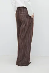 Pantalón de jean azul oscuro de tiro alto, con diseño holgado de pierna ancha, pinzas en la cintura y costuras a la vista.