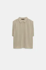 Camisa fluida de cuello solapa y manga corta, con diseño a rayas en tonos beige y blanco, detalle de pliegues en los hombros y cierre frontal con botones.