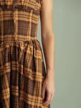 Vestido midi estilo corset con estampado a cuadros en tonos marrón y tostado, con breteles anchos y falda acampanada.