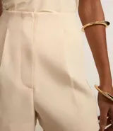 Mono corto color crema, con cuello halter y corte sastrero.