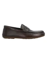 Mocasines de cuero marrón oscuro, con diseño clásico de tipo penny loafer, costuras visibles en el empeine y suela plana de goma.