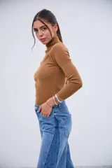 Polera de punto acanalado color dulce de leche, con cuello alto y mangas largas.