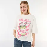 Remera oversize blanca de manga corta, con cuello redondo y estampa frontal estilo vintage que incluye un vaso de bebida y la inscripción "Matcha Lover Club".