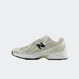 Championes urbanos New Balance modelo 740, color beige con detalles en blanco y negro. Presentan una parte superior de malla transpirable con superposiciones sintéticas, entresuela con tecnología ABZORB para amortiguación y suela de goma resistente.
