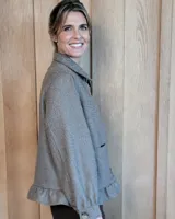 Sobrecamisa de pana color marrón oscuro, con cuello camisero, cierre frontal de botones y detalle de volado en el ruedo. Presenta mangas largas con puños y bolsillos frontales aplicados.