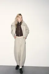Pantalón de tiro alto con cintura elástica ajustable mediante cordón. Presenta un corte recto y holgado con bolsillos laterales y traseros.