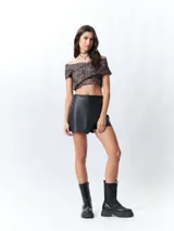 Top negro con estampado floral, escote off-shoulder, corte cruzado y mangas cortas.