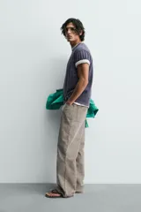 Camiseta de manga corta, corte holgado, color gris oscuro o azul marino con efecto lavado y rotos. Estampado frontal con el texto "WILTONWAY" en letras doradas.