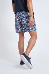 Short de baño con cintura elástica y cordón ajustable, confeccionado en tela ligera de secado rápido. Presenta un estampado botánico integral en tonos amarillos, blancos y azules, con dos bolsillos delanteros y uno posterior.