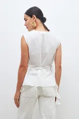 Blusa color crudo sin mangas con volado.