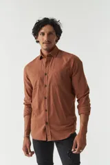 Camisa rústica lisa de manga larga color verde militar, con cuello clásico y dos bolsillos frontales con solapa.