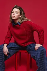 Sweater de tejido de punto negro con tramas de ochos en las mangas y laterales, cuello redondo a la base y mangas largas.