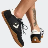 Championes Converse Run Star Trainer negros con detalles en blanco y suela de goma color caramelo.