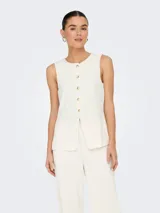 Chaleco corto color blanco hueso con cuello abierto y cierre frontal con botones. Confeccionado en tejido de punto con mezcla de poliéster y elastano. Diseño sin mangas con textura suave y calce ajustado.