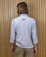 Camisa de algodón color blanco, con cuello alto con volados, mangas tres cuartos con detalles de bordado ingles y cierre frontal con botones de nácar.