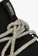 Zapatillas urbanas Schutz de tejido knit negro, con suela chunky blanca de diseño dentado y cordones decorativos de lurex brillante.