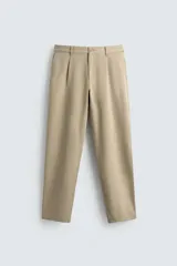 Pantalón de corte recto confeccionado en tejido elástico, con cintura elástica, pliegues frontales, bolsillos laterales y bolsillos traseros de vivo con botón.