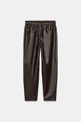 Pantalón de tiro alto confeccionado en material efecto piel, con cintura elástica ajustable mediante cordones, bolsillos delanteros y bolsillos de plastrón en la parte trasera.