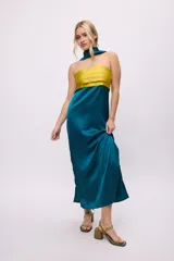 Vestido largo de satén color verde azulado, con cuerpo amarillo con tablas y bufanda integrada al cuello.