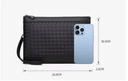 Sobre o clutch negro de eco cuero con diseño tejido en patrón de rombos. Incluye una correa de muñeca desmontable.