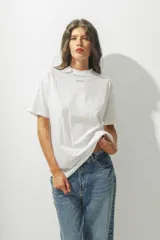Camiseta de algodón orgánico de corte holgado, color blanco, con cuello redondo y logo pequeño bordado en el centro del pecho.