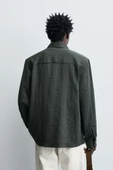 Camisa de corte relajado confeccionada en tejido fluido con mezcla de viscosa. Presenta cuello solapa, cierre frontal con botones y manga larga con puños abotonados.