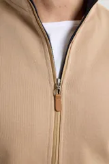 Cardigan de tejido de punto color verde militar, con cierre frontal de metal y cuello redondo. Presenta detalle de tejido plano en la cartera del cierre y en los bolsillos laterales.