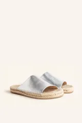 Sandalias tipo alpargata con capellada de cuero charol color bordó y planta tejida en fibra natural de yute. Presentan costuras a mano en color blanco y suela de goma.