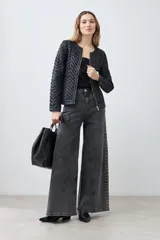 Chaqueta negra de cuero sintético con diseño acolchado en forma de espiga y detalles de tul.