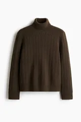 Polera de punto texturizado en color marrón oscuro, con cuello alto acanalado y puños y bajo con terminación acanalada. Presenta un corte estándar.