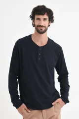 Remera de manga larga con cuello henley y cierre frontal de tres botones. Confeccionada en tejido de algodón, presenta un corte clásico y versátil.