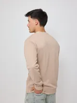 Sweater color arena con logo Rusty estampado en el pecho, de corte regular fit.