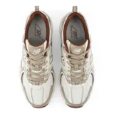 Championes New Balance modelo 530, color beige y blanco con detalles en marrón, confeccionados en malla transpirable y superposiciones de cuero sintético. Cuentan con entresuela con tecnología ABZORB y el característico logo "N" en los laterales.