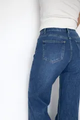 Pantalón de jean corte wide leg en color azul oscuro, con tiro medio-alto y detalle de dobladillo ancho en la botamanga que contrasta con el tono del resto de la prenda.