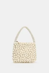 Bolso de mano pequeño con diseño estructurado, completamente cubierto de abalorios perlados. Cuenta con un asa superior también decorada con cuentas y cierre de cremallera metálica.