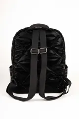 Mochila plateada capitoneada tipo puffer con compartimentos laterales, dos bolsillos externos con cierre y tres bolsillos adicionales en su interior. Cuenta con un asa fija en la parte superior y dos regulables en la espalda.