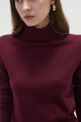 Polera de lyocell color negro, con cuello alto y ajuste al cuerpo, de manga larga.